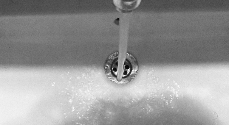 Water flows from the faucet into the sink.